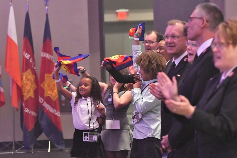Children wave glory flags at the conclusion of commissioning weekend