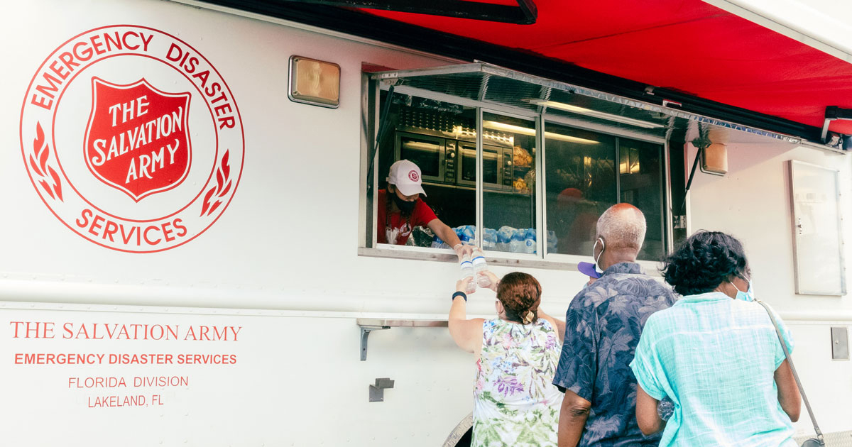 Salvation Army personnel hand out water to people affected by hurricane Ida