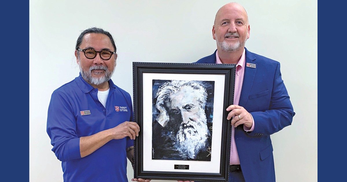 Vernon Miike (left) and Ted Troughton hold the portrait of Salvation Army co-Founder General William Booth. “I was captivated by him,” Vernon says. “He was a man who dedicated his life to helping others”
